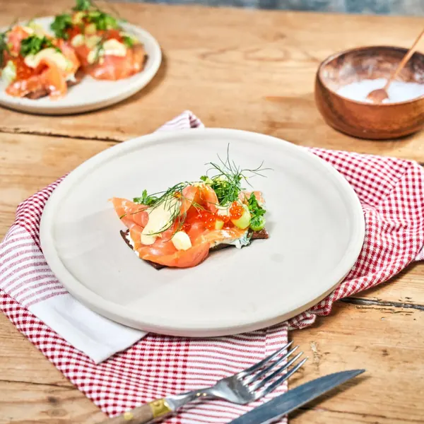 Toast with smoked salmon, dill and cream cheese on a red checked cloth