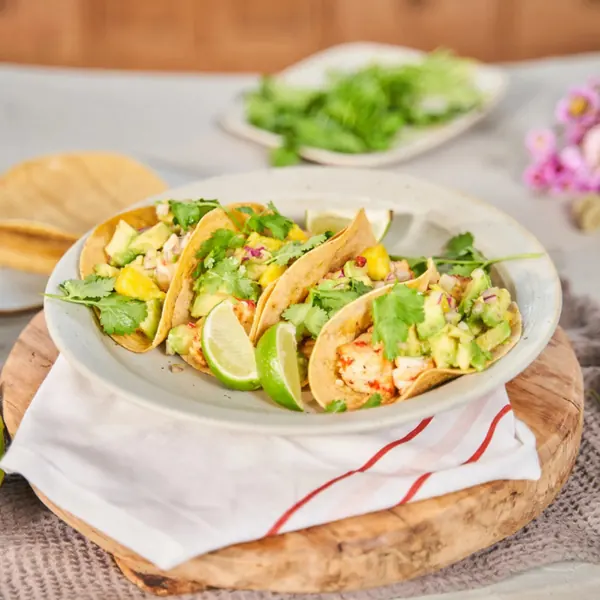 Three fish tacos with lime, avocado and coriander